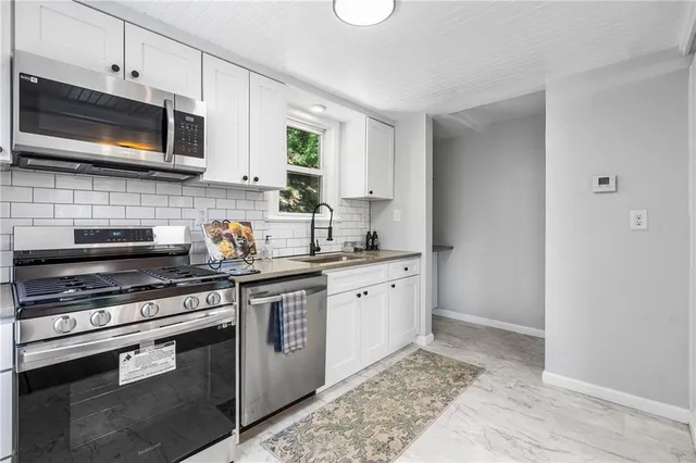 a kitchen with stainless steel appliances granite countertop a stove microwave and sink