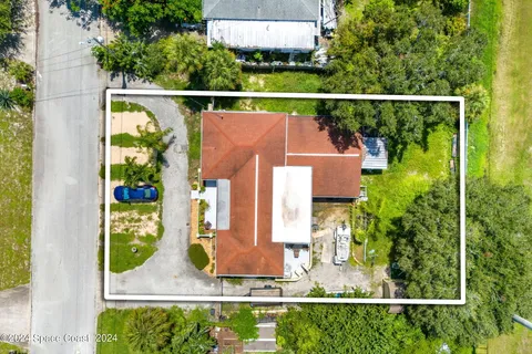 an aerial view of residential houses with outdoor space and trees