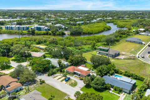 an aerial view of a house with a yard swimming pool and outdoor seating