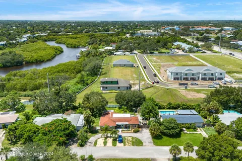 an aerial view of residential houses with outdoor space and swimming pool
