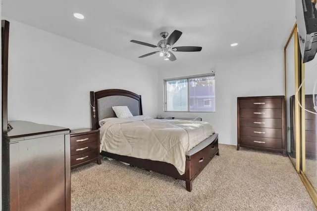 a spacious bedroom with a bed and a dresser with the dresser