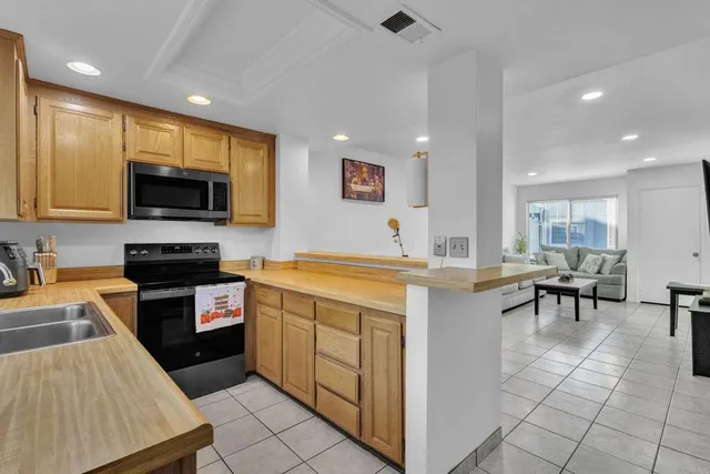 a kitchen with stainless steel appliances granite countertop a sink a stove a microwave a counter top space and cabinets