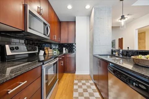 a kitchen with stainless steel appliances granite countertop a stove and a sink