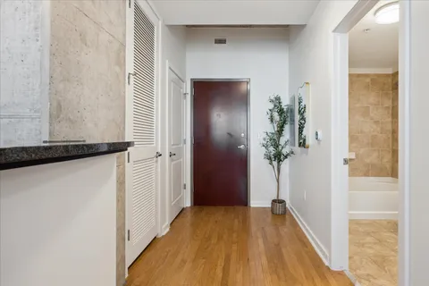 a view of a hallway with wooden floor and front door