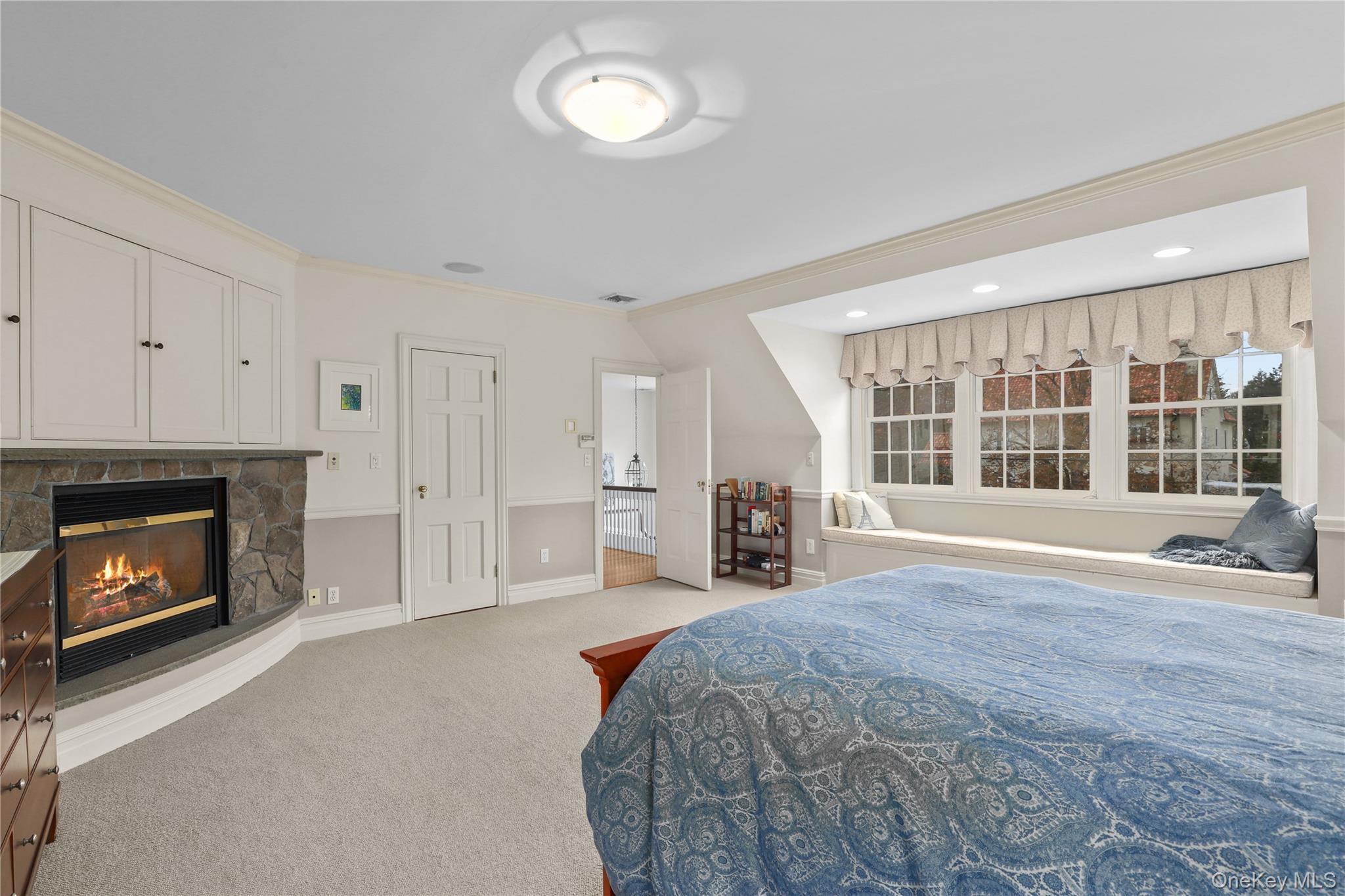 12 Sunnybrae Place Bronxville, NY 10708 - Photo 14 of 40 Primary Bedroom with crown molding, carpet flooring, and a stone gas fireplace