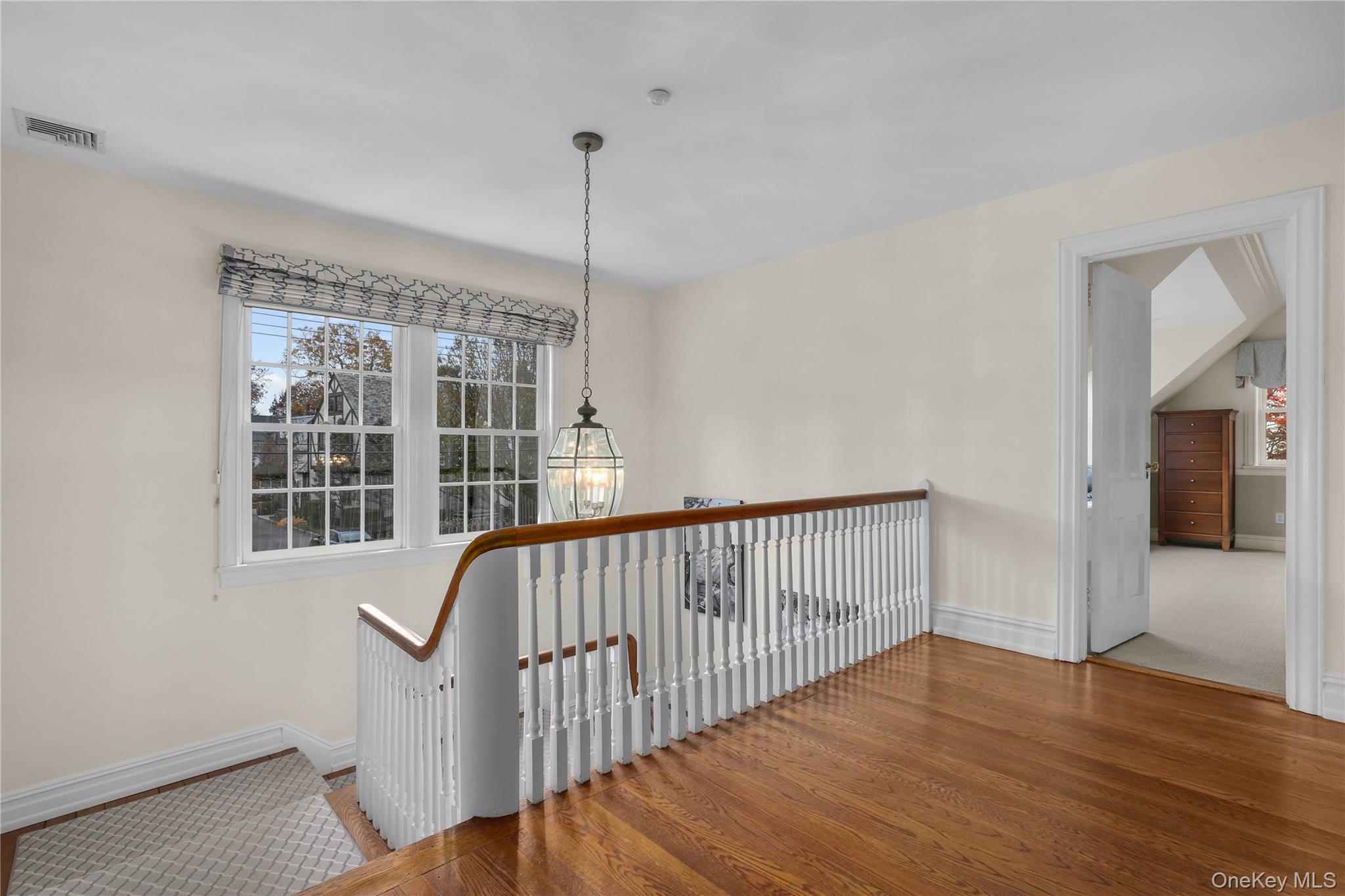 12 Sunnybrae Place Bronxville, NY 10708 - Photo 22 of 40 Hallway with wood finished floors, an upstairs landing, and a chandelier