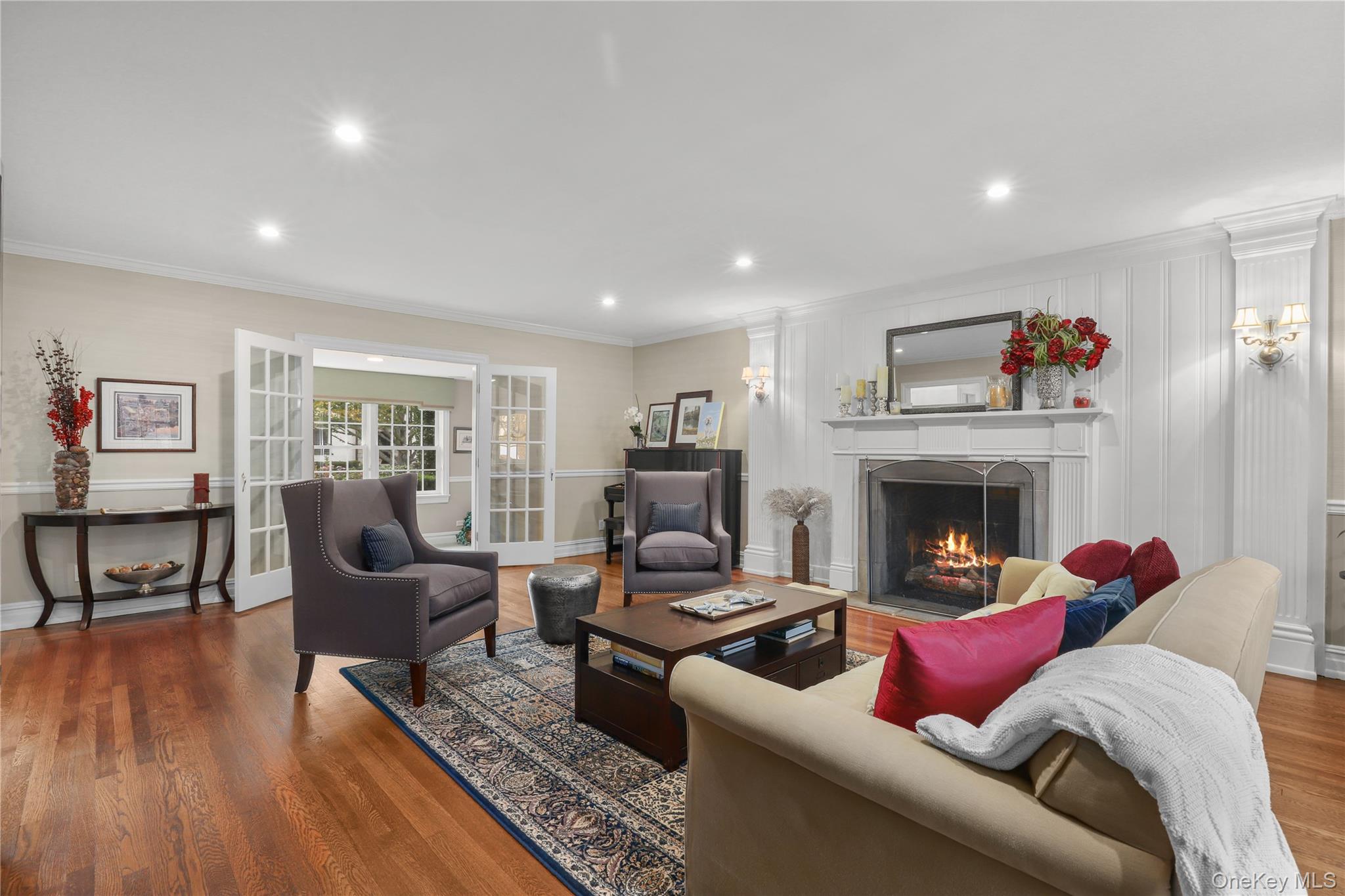 12 Sunnybrae Place Bronxville, NY 10708 - Photo 3 of 40 Living room with a gas fireplace, recessed lighting, ornamental molding, wood finished floors, and french doors
