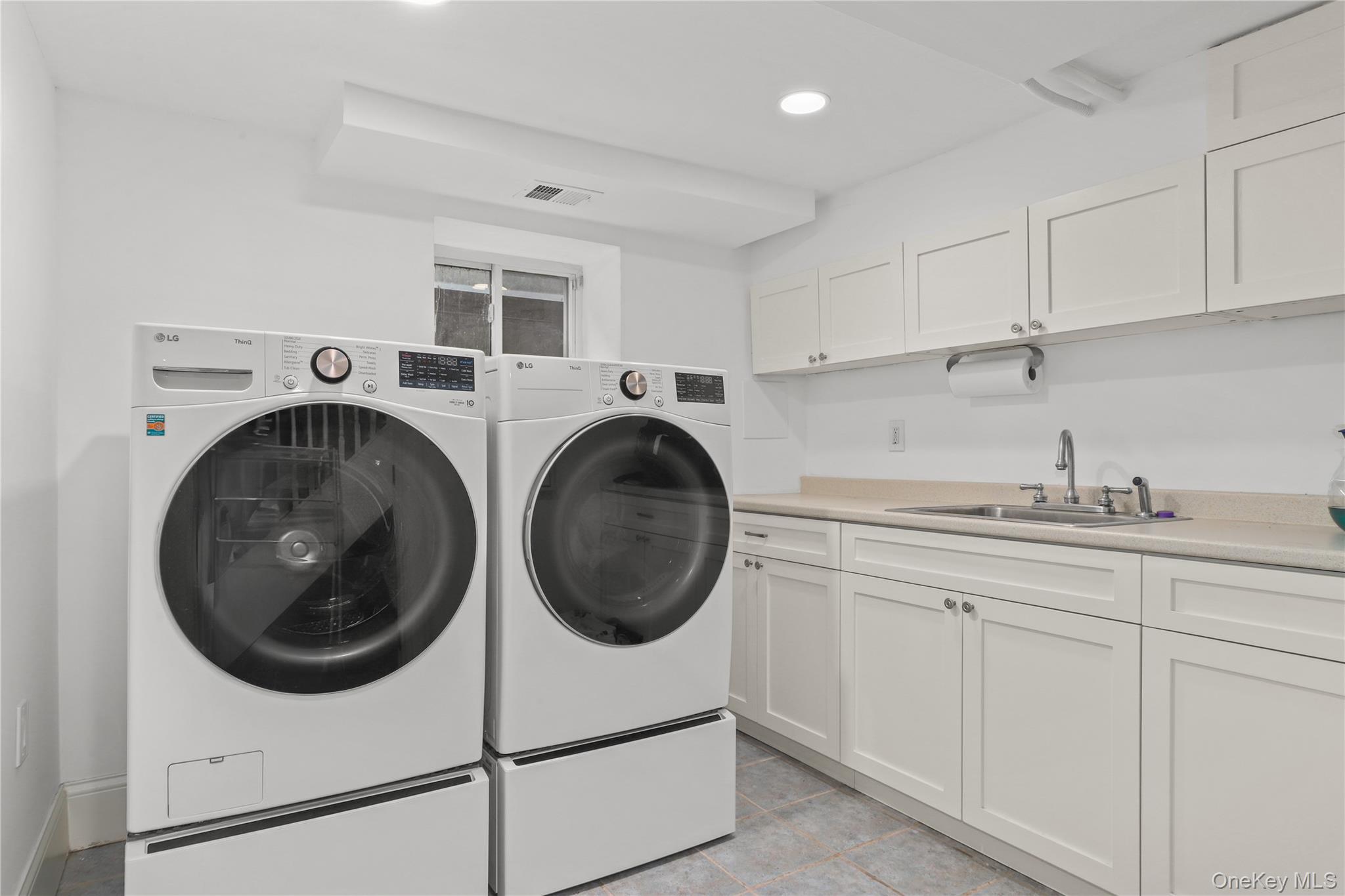 12 Sunnybrae Place Bronxville, NY 10708 - Photo 31 of 40 Laundry area featuring recessed lighting, washing machine and clothes dryer, light tile patterned floors, and cabinet space