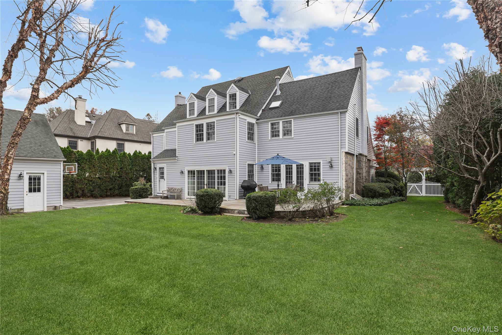 12 Sunnybrae Place Bronxville, NY 10708 - Photo 33 of 40 Rear view of property with a chimney, a yard, a patio, and a shingled roof