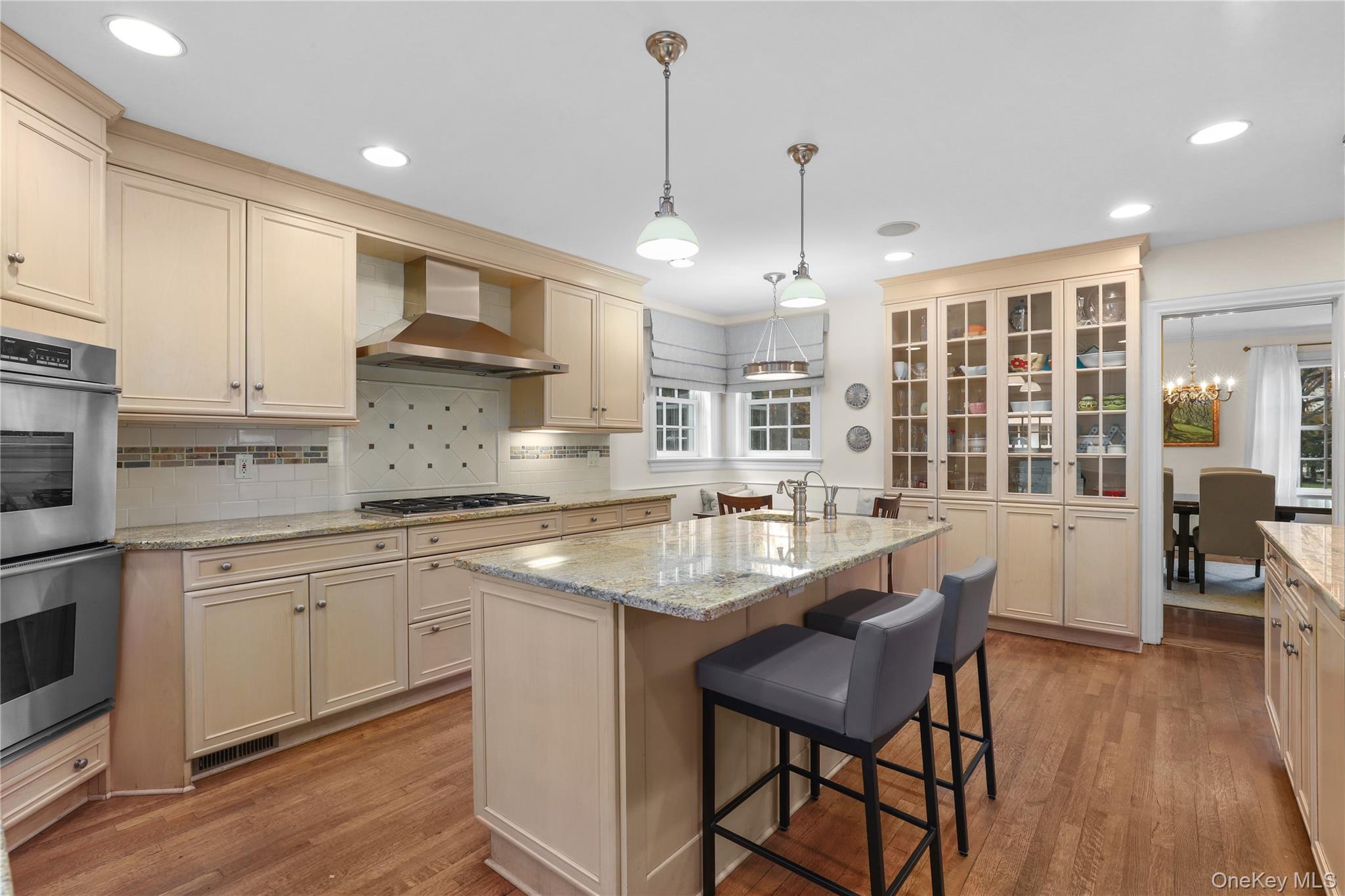 12 Sunnybrae Place Bronxville, NY 10708 - Photo 9 of 40 Kitchen featuring cream cabinets, light stone counters, backsplash, and recessed lighting