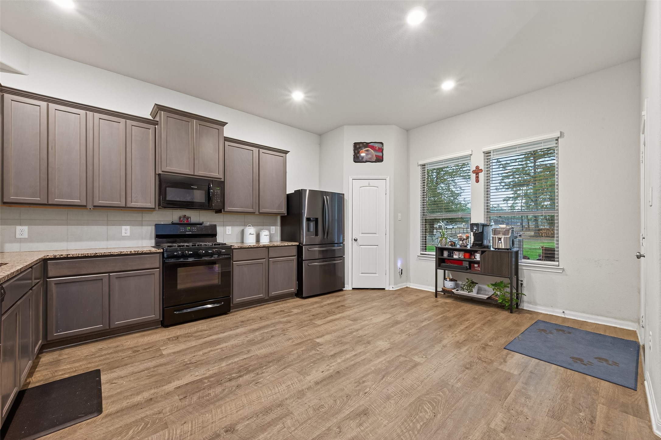 16601 Crosby Street Conroe, TX 77303 - Photo 13 of 50 Spacious kitchen featuring abundant cabinet storage, granite countertops, gas cooking, and stainless steel appliances, with a bright breakfast area overlooking the backyard.