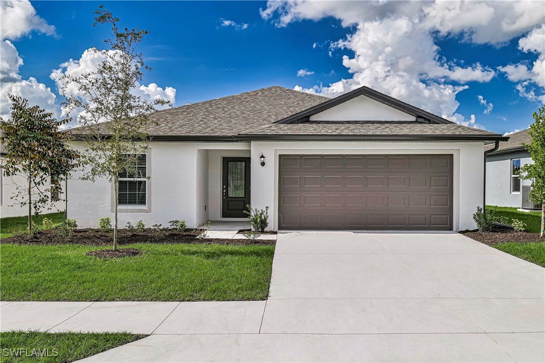 1314 Bush Street West Immokalee, FL 34142 - Photo 1 of 20 a front view of a house with a yard and garage