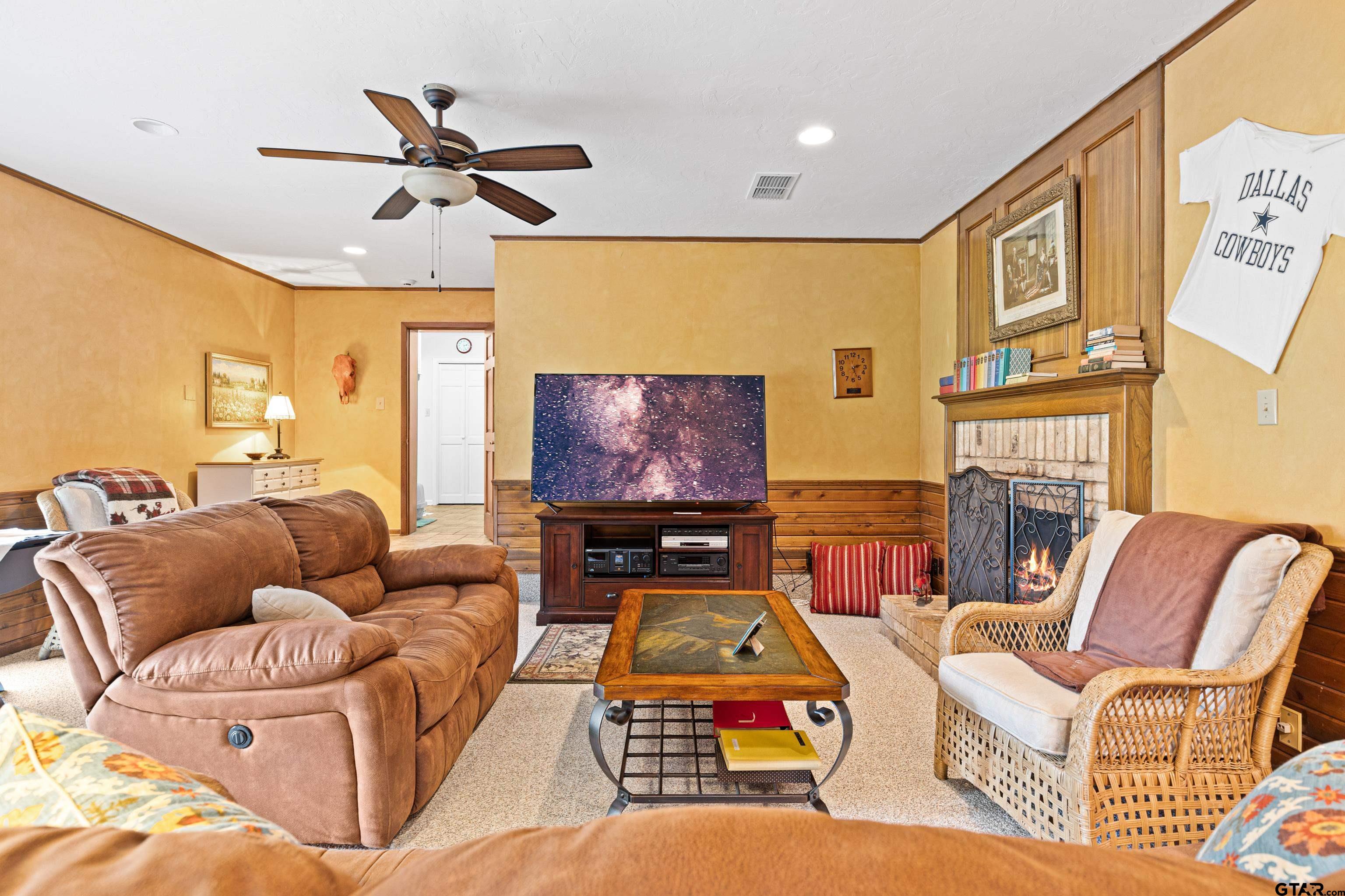 1610 Pinecrest Street Gilmer, TX 75644 - Photo 23 of 40 a living room with furniture a ceiling fan and a flat screen tv