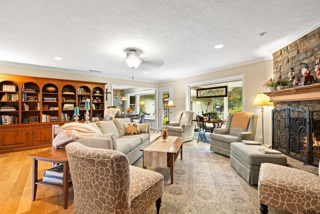 a living room with fireplace furniture and a large window