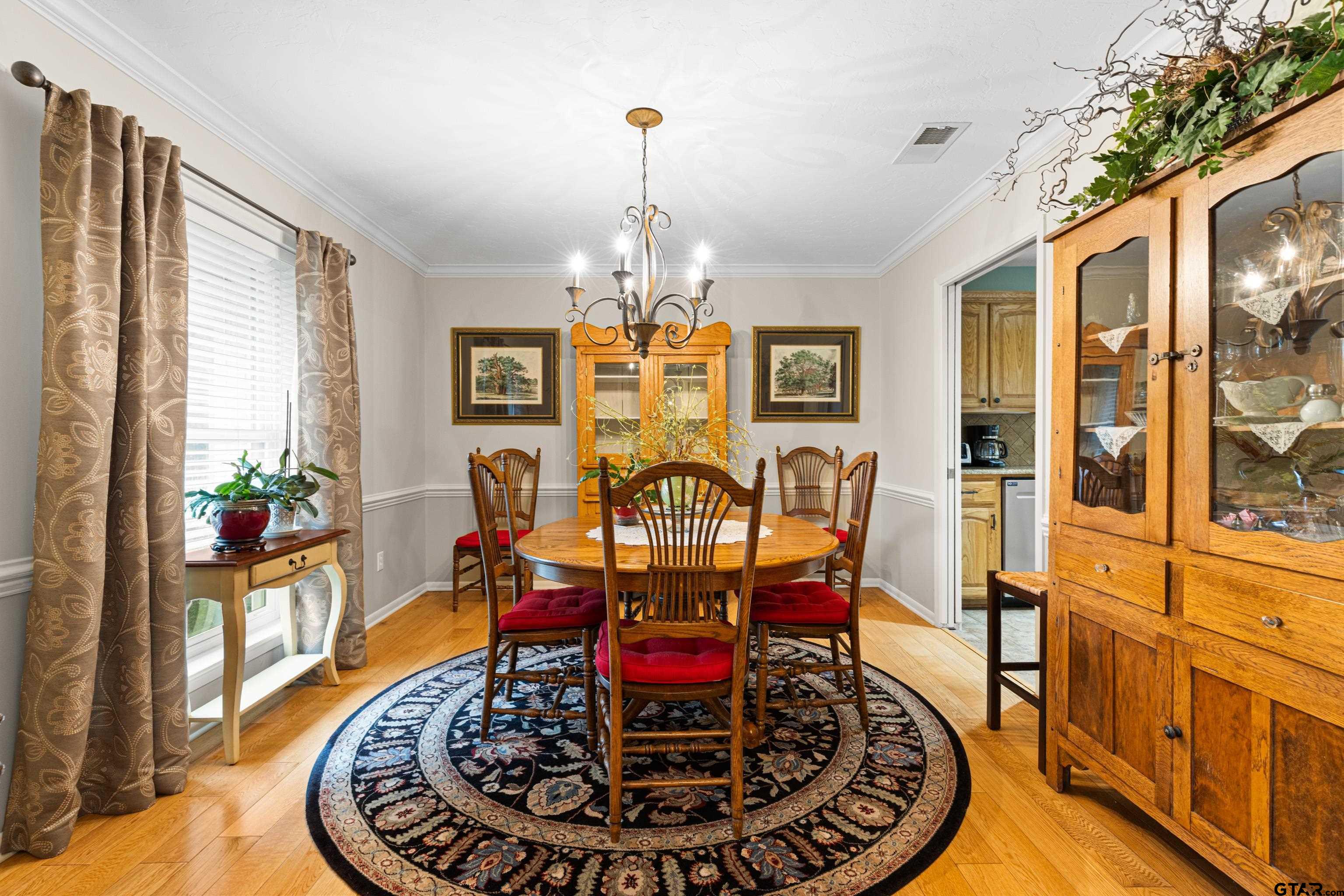 1610 Pinecrest Street Gilmer, TX 75644 - Photo 10 of 40 a view of a dining room with furniture a chandelier and wooden floor