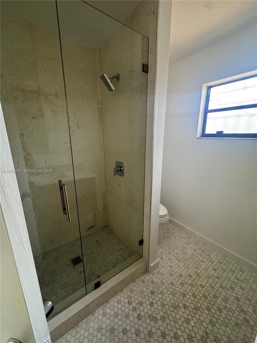 252 Northwest 48th Place, Unit 252 Miami, FL 33126 - Photo 5 of 15 a bathroom with a glass door shower