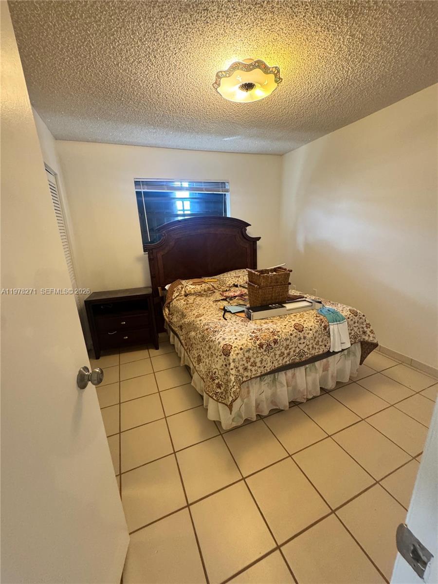 252 Northwest 48th Place, Unit 252 Miami, FL 33126 - Photo 10 of 15 a bedroom with a bed and a shower