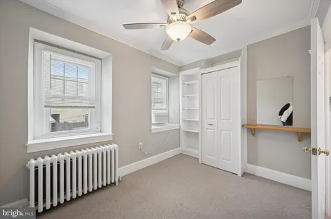 an empty room with windows and closet area