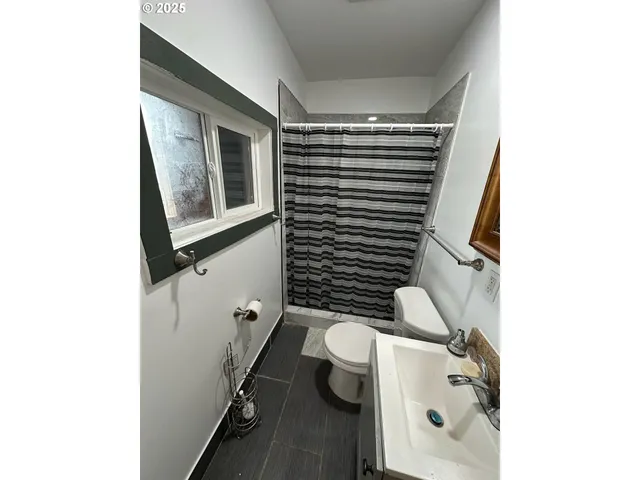 a bathroom with a toilet a sink and mirror