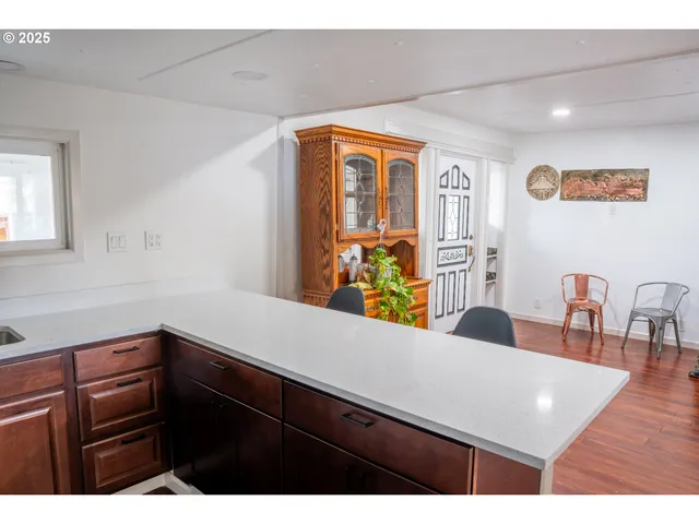 a view of a kitchen area with furniture and wooden floor