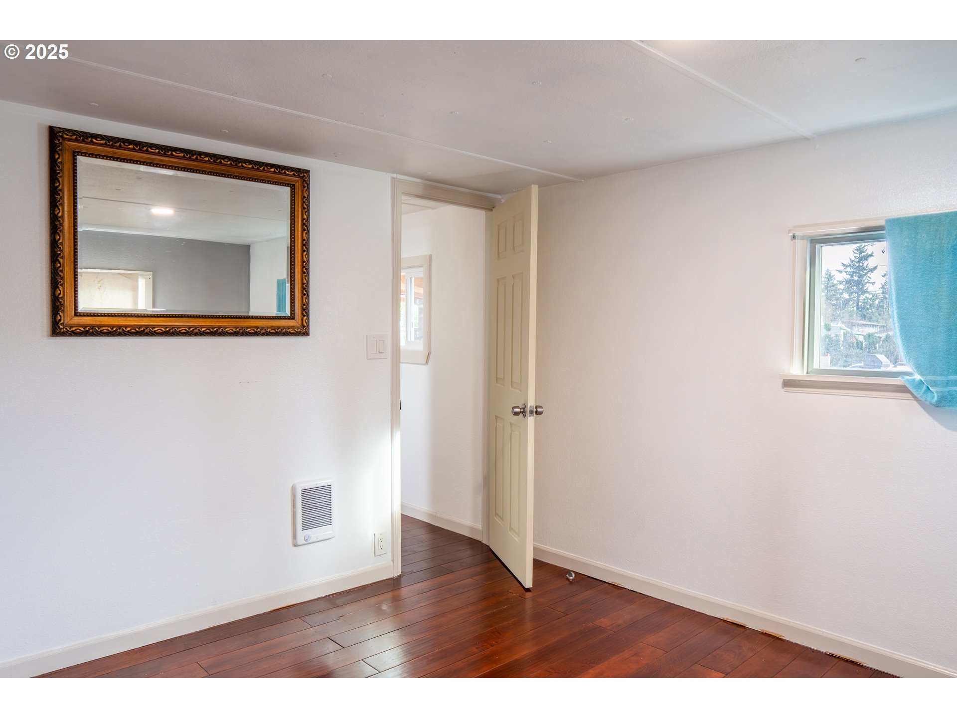 11803 Southeast Division Street, Unit 38 Portland, OR 97266 - Photo 5 of 24 a view of an empty room with wooden floor and a window