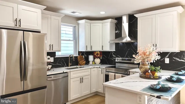a kitchen with stainless steel appliances kitchen island granite countertop a refrigerator and microwave