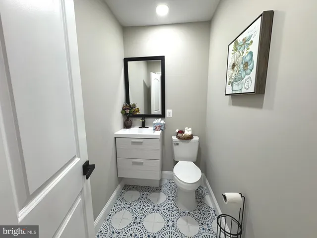 a bathroom with a granite countertop toilet sink and mirror