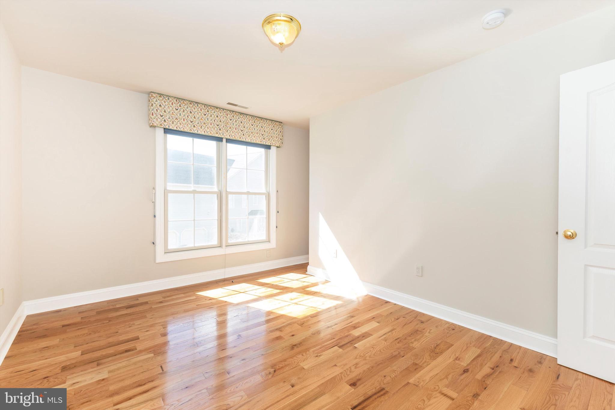 10213 Deep Skies Drive Laurel, MD 20723 - Photo 38 of 56 an empty room with wooden floor and windows
