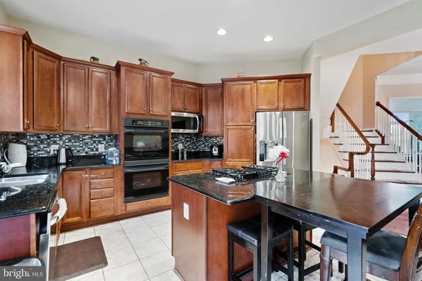 a kitchen with stainless steel appliances a sink stove and cabinets