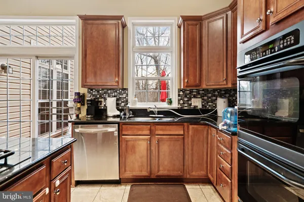 a kitchen with stainless steel appliances granite countertop a sink and a stove
