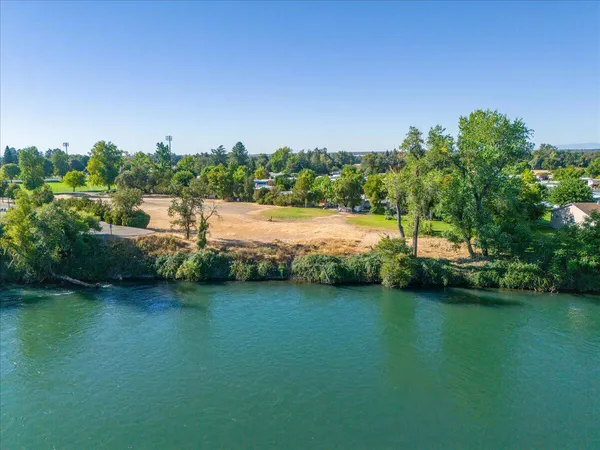 an aerial view of residential houses with outdoor space and lake view