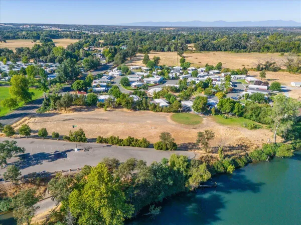 an aerial view of residential houses with outdoor space and lake view