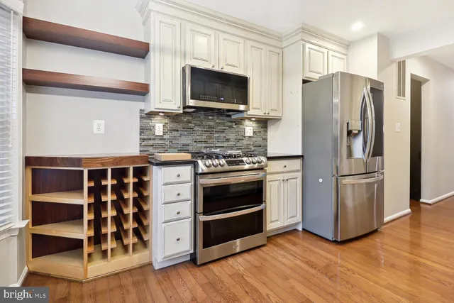 a kitchen with stainless steel appliances and wooden floor