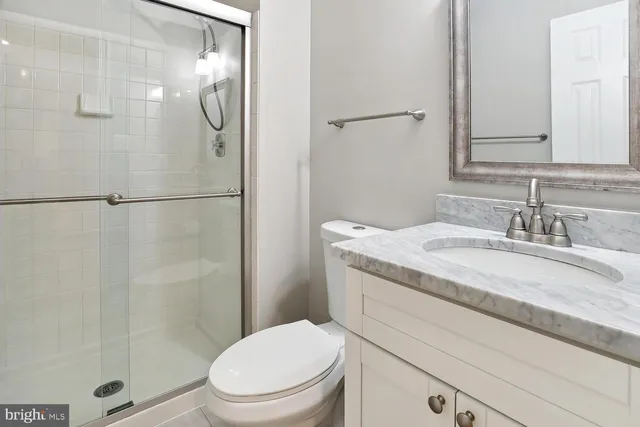 a bathroom with a granite countertop sink toilet and shower