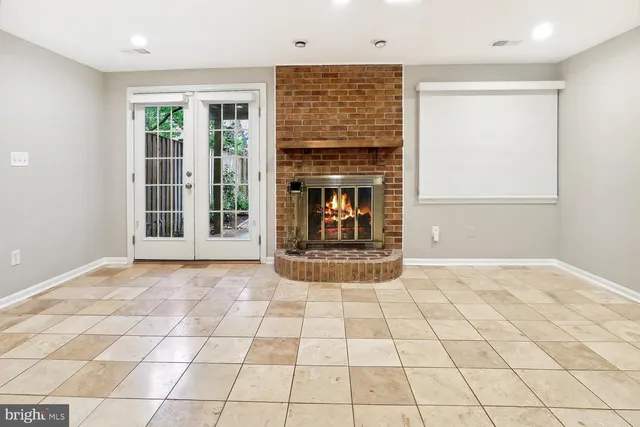 a view of an empty room with glass door and fire place