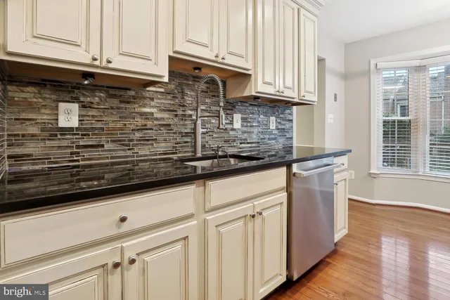 a kitchen with granite countertop white cabinets and stainless steel appliances