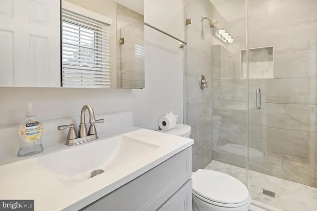 a bathroom with a sink a toilet and shower