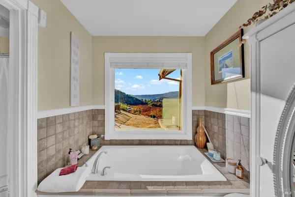 a bed sitting in a spacious bedroom next to a window