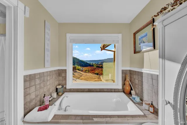 a bed sitting in a spacious bedroom next to a window