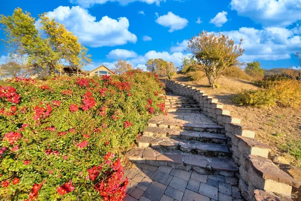 an aerial view of residential houses with outdoor space and trees