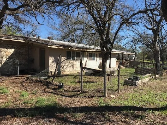 a view of a backyard that has a tree on the side of it