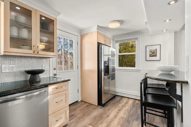 a kitchen with stainless steel appliances granite countertop a refrigerator and a stove top oven