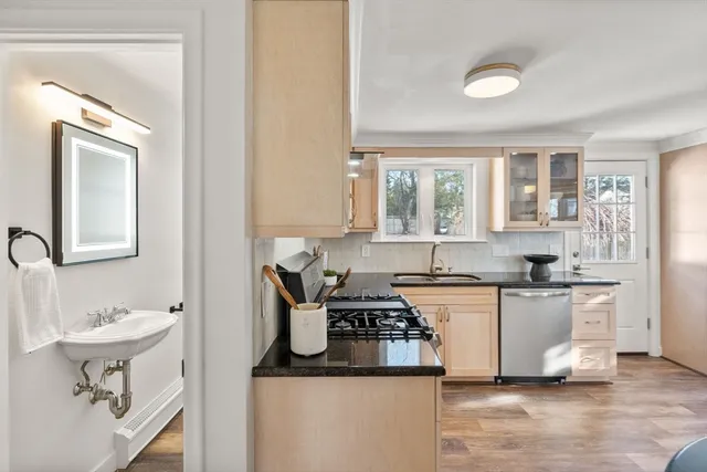 a kitchen with a sink appliances cabinets and a window