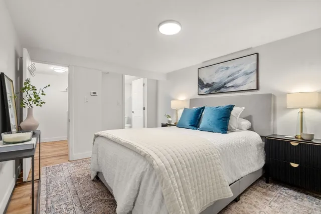 a bedroom with a bed and a painting on the wall