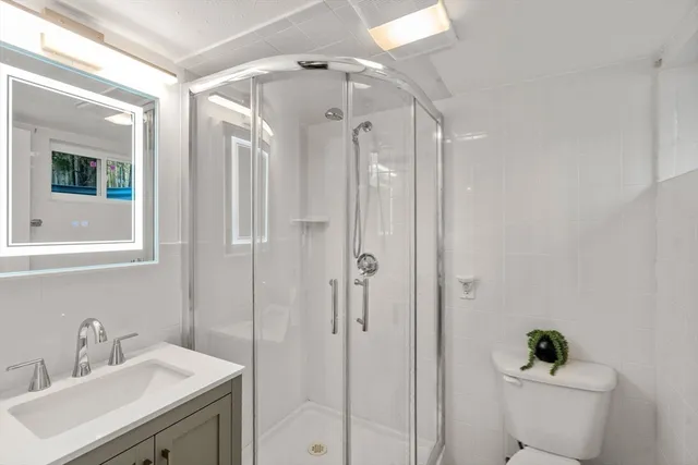 a bathroom with a sink a toilet and shower