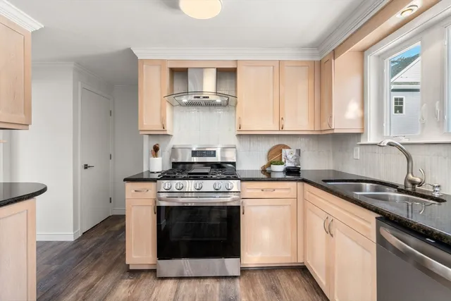 a kitchen with stainless steel appliances a stove a sink and cabinets