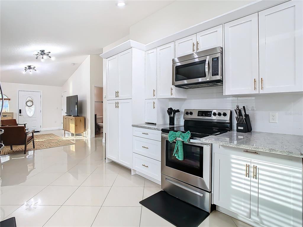 2907 West Arch Street Tampa, FL 33607 - Photo 11 of 48 a kitchen with stainless steel appliances granite countertop a stove a microwave and a refrigerator