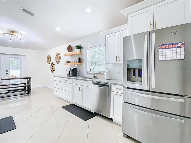 a kitchen with white cabinets and appliances