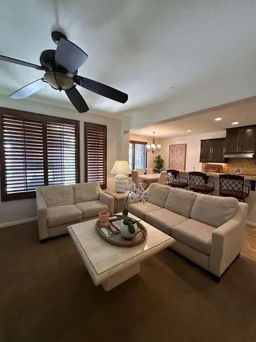 a living room with furniture kitchen view and a large window