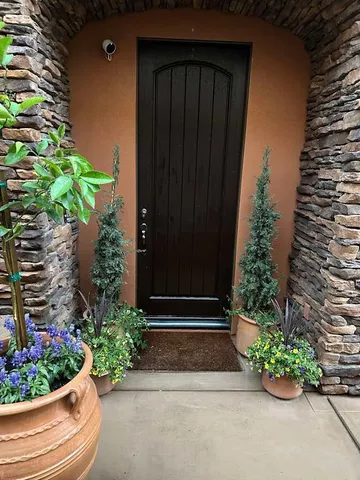a view of a entryway door with flower plants